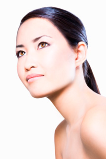 Young asian woman with bare shoulders looking up and with hair pulled behind ears