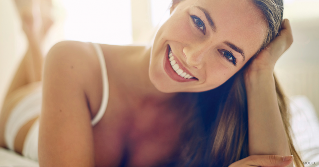 Woman is smiling after her breast augmentation.