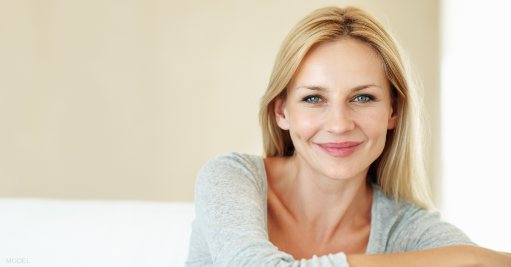 Beautiful mature woman sitting on couch smiling (model)