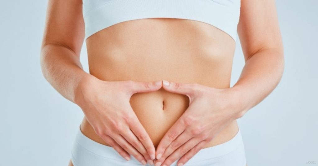 Woman with hands on her stomach (model)